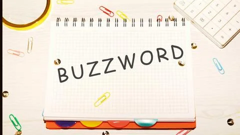 Buzzword word on a checkered notebook on a light table next to a magnifying.. Stock Photos