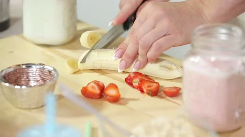 Bvp 28beautiful woman's hands cut strawberries and banana a with fruit yogurt Stock Footage