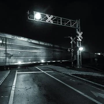 BW train crossing at night Stock Photos