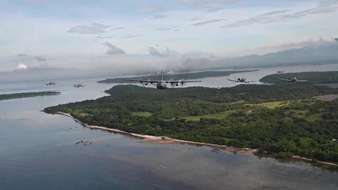 C-130 Hercules flying over islands with A-10 Thunderbolts and A-29 Super Tucanos Stock Footage 295775084