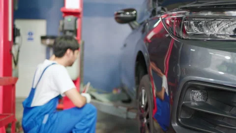 C0020 Mechanic man worker using hoist to lift down the car Video stock 204719888