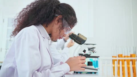 C0020 Young scientist lookning at microscope in the laboratory Видео 206092280