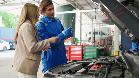 C0021 Car mechanic worker talking with lady customer at garage Stock Footage 204719791