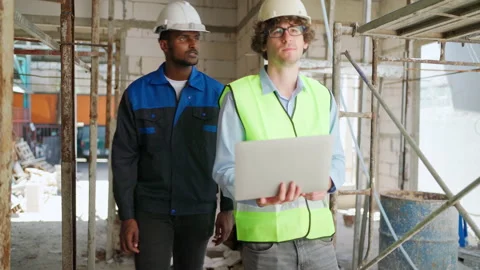 C0058 Engineer and architectural holding laptop and walking on site Stock Footage 204924835