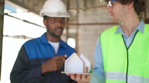 C0062 Engineer and architectural holding house model and discuss on site Видео 204924670