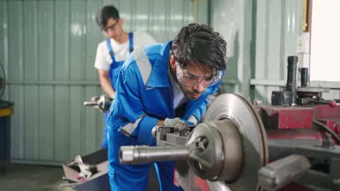 C0095 2 Worker using lathe tool to make flat surface of brake disc Stock Footage 204719295