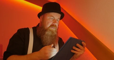 C4K Bearded man is annoyed while surfing the internet using tablet 库存影片 108117273