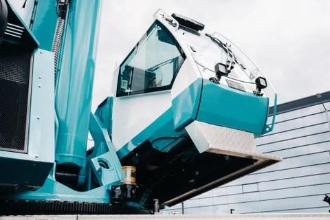 A cab with the operator of a Large blue car crane that stands ready to operat Stock Photos