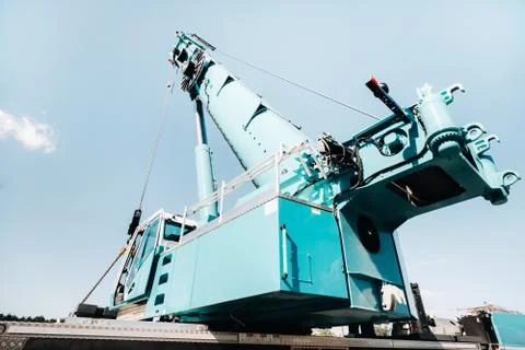 A cab with the operator of a Large blue car crane that stands ready to operat Stock Photos