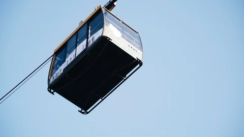 A cab with people rides on a cable car. Movement and transport. Stock Footage 122774638