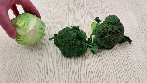 Cabbage and Broccoli Florets on Light Wooden Kitchen Surface Stock Footage 327357592