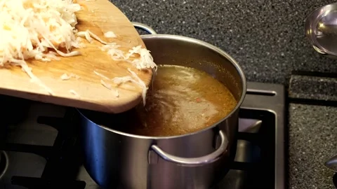 Cabbage with carrots is placed in a boiling broth. Soup preparation Stock-Footage 168411949