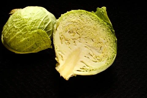 Cabbage cut in half on a black surface Stock Photos