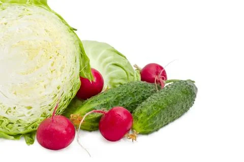 Cabbage cut in half closeup, two cucumbers and red radish Stock Photos