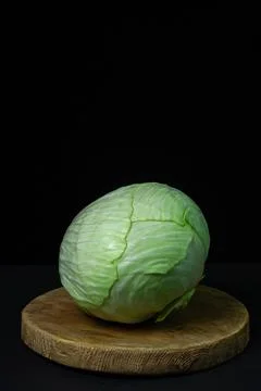 Cabbage on a dark background. Head of fresh cabbage on a black background.  Stock Photos