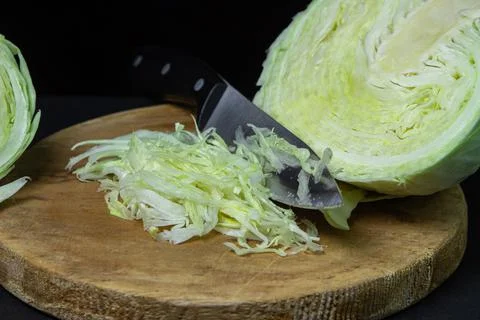 Cabbage on a dark background. Shredded cabbage on a black background. Stock Photos