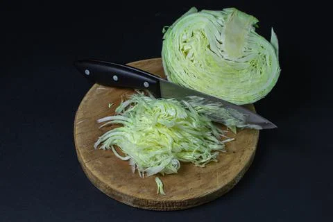 Cabbage on a dark background. Shredded cabbage on a black background. Stock Photos