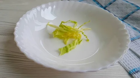 Cabbage drops into a plate slow motion Stock Footage 89765604