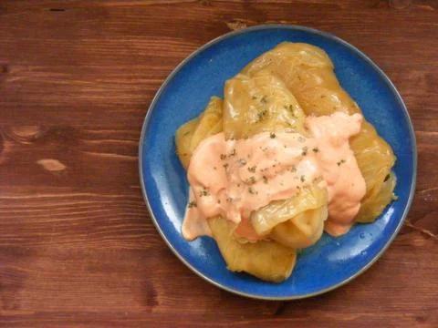 Cabbage roll , stuffed cabbage on blue plate on wooden background flat view Stock Photos