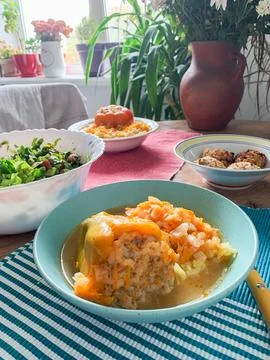Cabbage rolls filled with meat and grains sit in a blue bowl. The dish is cov Stock-Fotos