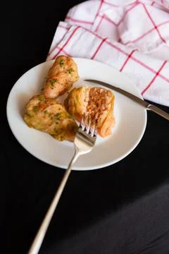 Cabbage rolls served on a white plate with fork on a black table with a che.. Stock Photos