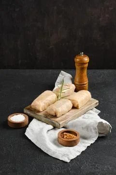 Cabbage spring rolls stuffed with meat ready for cooking on a wooden board .. Stock Photos