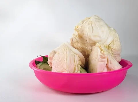 Cabbage vegetables on a pink container for vegetables on a white background Stock Photos