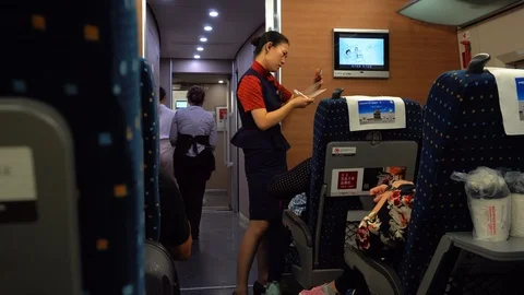 Cabin crew checking passenger ticket inside China bullet high Speed train Stock Footage 119924161