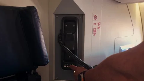 Cabin Crew Menber Grabbing the Emergency Intercom Handset Inside Airplane Stock Footage 329004337