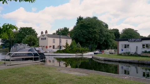 Cabin Cruiser passing through Saul Junction on Sharpness - Gloucester Canal, UK Stock Footage 114555675