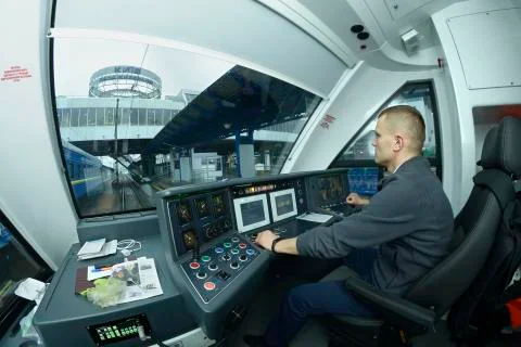 At the cabin of the passenger train. Train driver sitting in front of the das Stock Photos