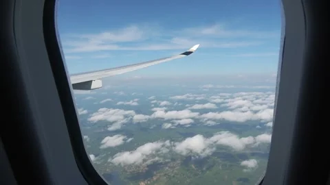 Cabin view: an airplane flying above mountain peaks and clouds. Stock Footage 335735573