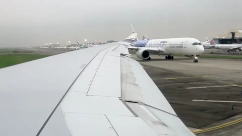 Cabin window view: a line of airplanes taxiing for takeoff on 2026.04.11. Stock Footage 332617311