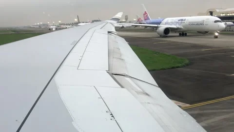 Cabin window view: a line of airplanes taxiing for takeoff on 2026.04.11. Stock Footage 332617799