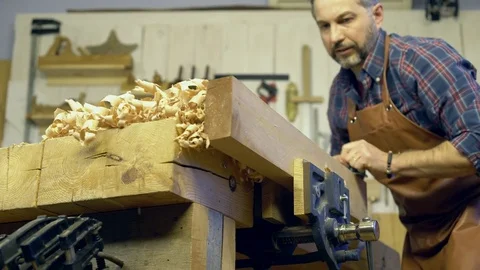 Cabinet Maker Planes Solid Wood in his Workshop Stock Footage 84909729