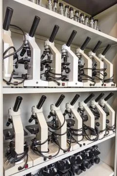 Cabinet with rows of microscopes on high school Stock Photos