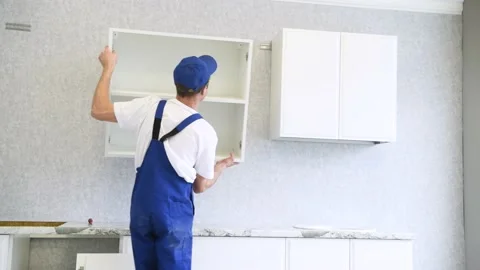 Cabinet shelf installation. Worker assembling furniture Stock Footage 131398642