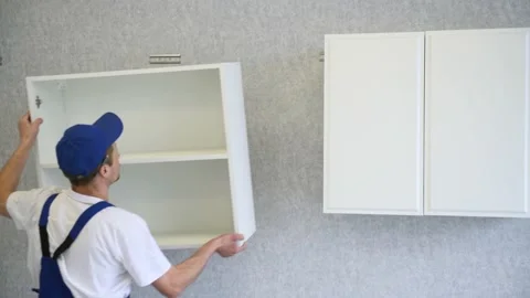 Cabinet shelf installation. Worker assembling kitchen furniture Stock Footage 131398656