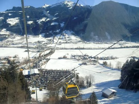 The cabins of the cable car descend down to the winter ski resort and car Stock Photos