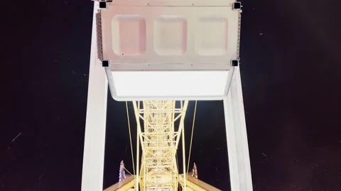 Cabins of Ferris wheel attraction move over night sky Stock Footage 231569275