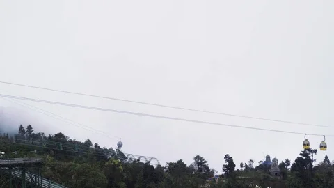 Cabins moving on funicular against sky with sun above trees. Danang.Vietnam Stock Footage 74819932