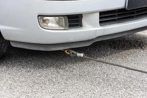 Cable attached to broken down car being pulled onto tow truck Stock Photos