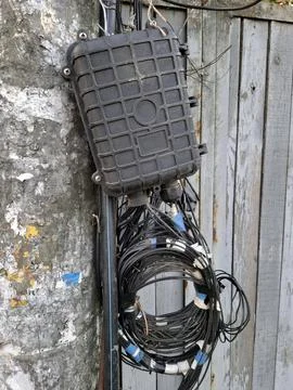 Cable box. Black wires on pole and optical coupling for cables Fotos de archivo