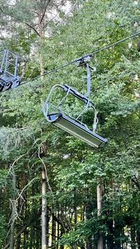 Cable car and bench with trees in the background Stock Photos
