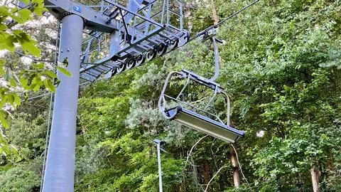 Cable car and bench with trees in the background Foto stock