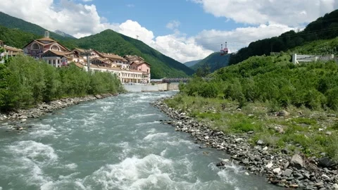Cable car cabins move over a mountain river, a ski resort for summer holidays. Stock Footage 242586988