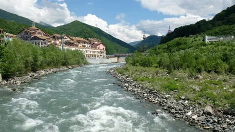 Cable car cabins move over a mountain river, a ski resort for summer holidays. Stock Footage 242587020
