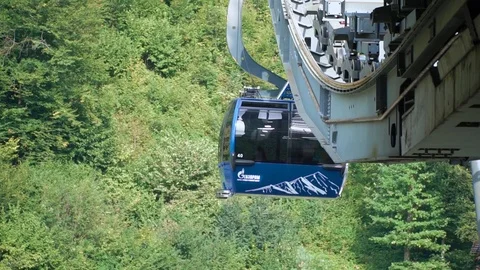 Cable car cabins moving on rope way for passenger transportation across forest Vidéo 121860006