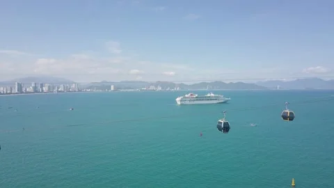 The cable car cabins pass by with a view of the sea and a cruise liner Stock-Footage 286030146