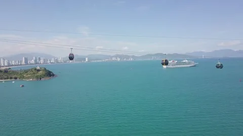 The cable car cabins pass by with a view of the sea and a cruise liner Stock Footage 286030701